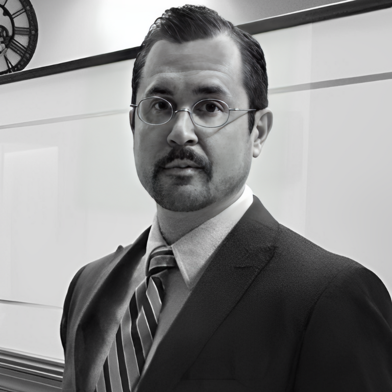 Portrait of an wearing glasses in suit in front of a whiteboard