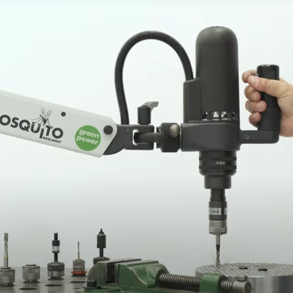 Operator effortlessly maneuvering a Roscamat®USA tapping arm with a selection of attachments displayed on a nearby table, highlighting its versatility and ease of use.